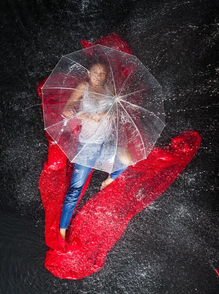 Woman with transparent umbrella under rain