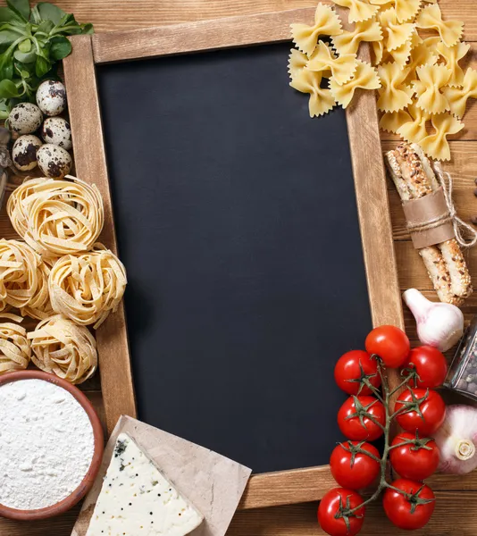 Italian food on vintage wood background with chalkboard