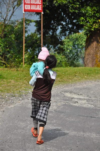 Girl holds baby walk in the stree