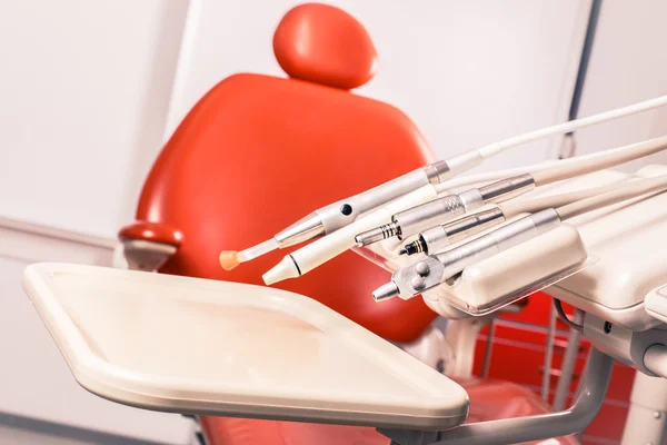 Dental tools and instruments for tooth dental care in front of dentist chair.