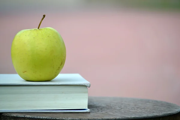 Apple and book on wood