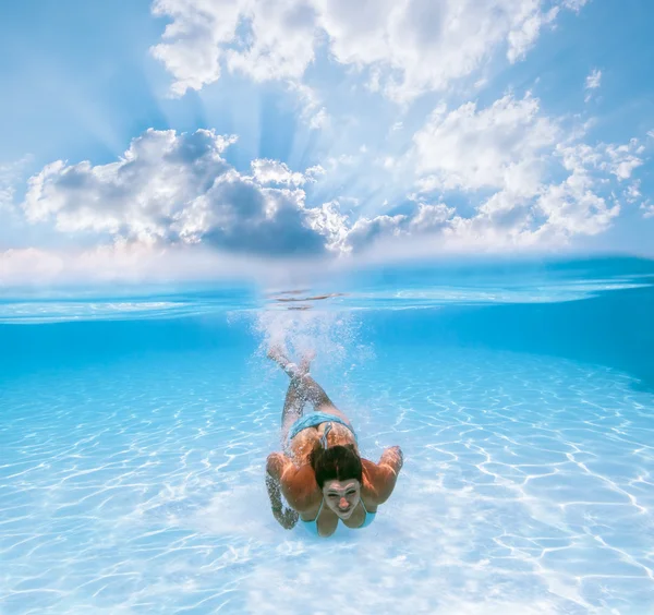 Girl swims under water in the pool