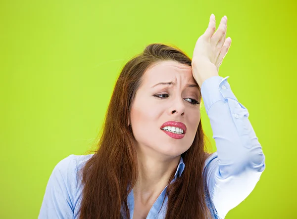 Woman with hand on forehead very upset