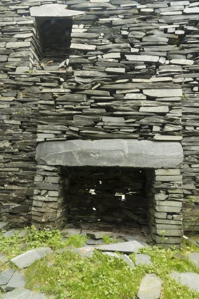 Old fireplace in ruined slate house