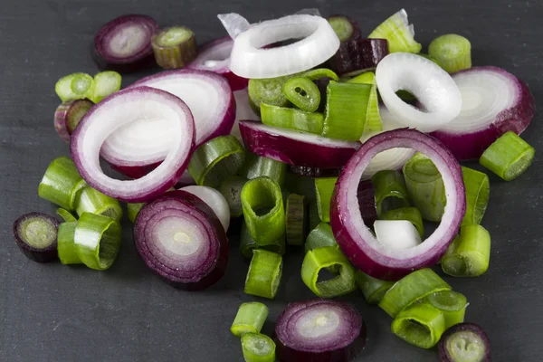 Slices of allum purple and green salad spring onions, scallions,