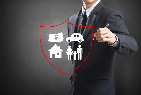 Business man drawing shield protecting family, house, car, money.