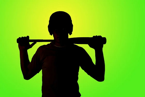 Green background of silhouette of baseball player holding his ba