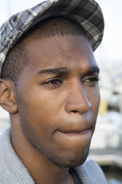 Black male model portrait with pursed lips wearing derby hat