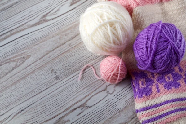 Ball of yarn and knitting on a wooden table