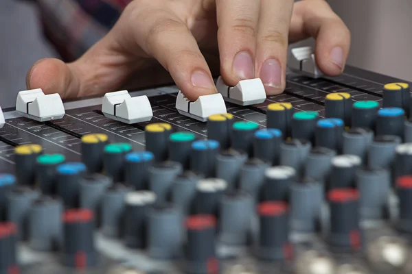 Fingers operating sound console