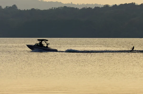 Young guy cruising on a jet ski during sunset