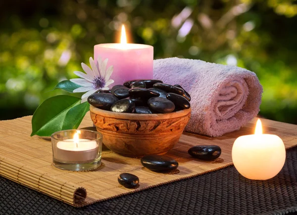 Jar of black stones and candles on mat