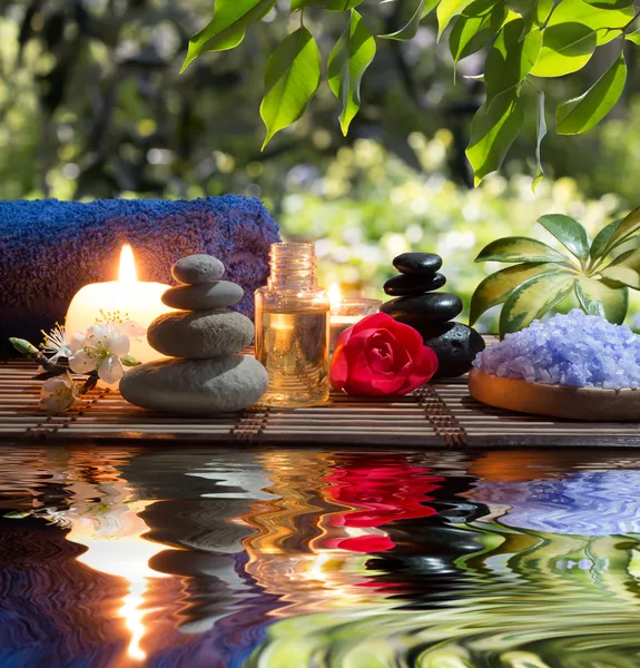 Massage in the garden: candles, towels, stones and almond flowers in water
