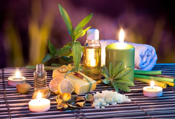 Lemon soap , oil, towel, salt, bamboo, and candles in garden