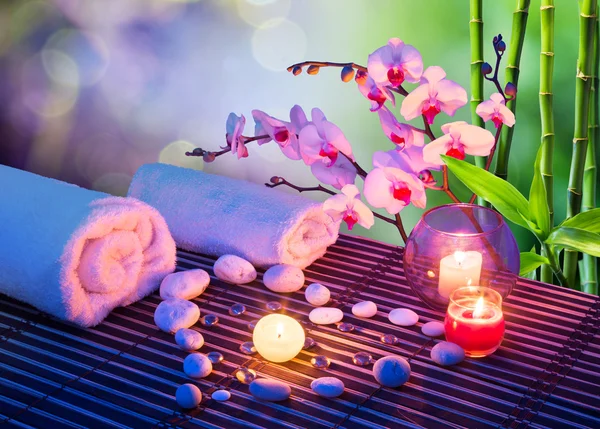 Heart of stones massage with candles, orchids, towels and bamboo