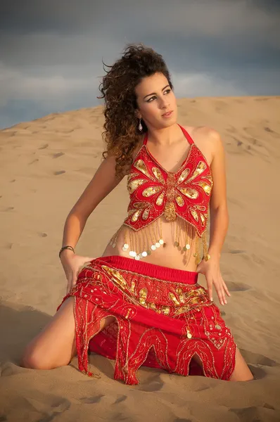 Woman belly dancer in desert dunes
