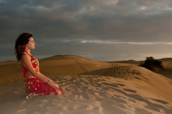 Woman belly dancer in desert dunes