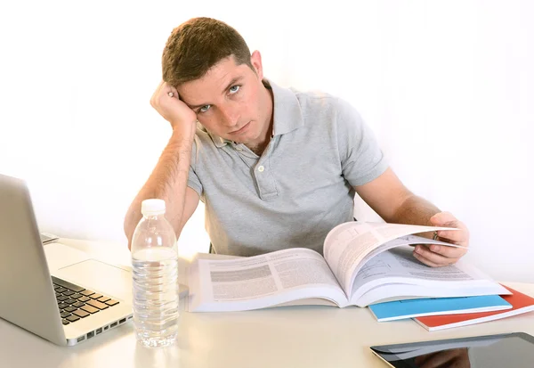 Stressed Student with Book and Laptop