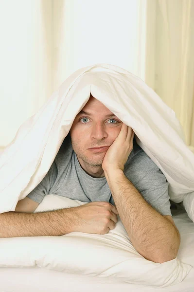 Man in bed with eyes opened suffering insomnia and sleep disorder