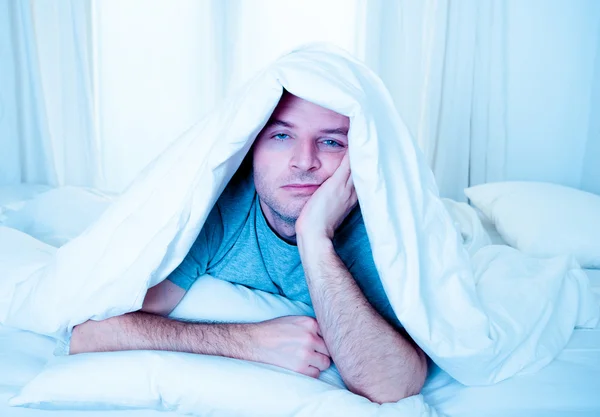 Man in bed with eyes opened suffering insomnia and sleep disorder