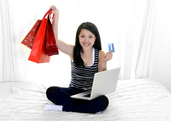 Asian american woman with credit card and shopping bags