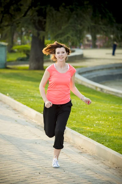 Pretty red haired woman running in the park