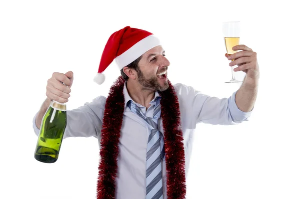 Businessman drinking champagne wearing a santa hat on white back