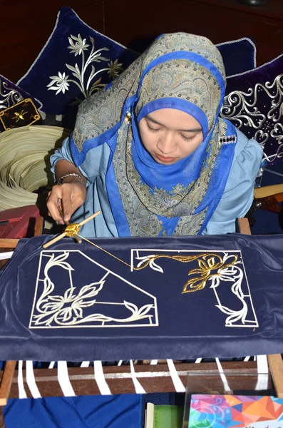PAHANG, MALAYSIA - NOV 10: Muslim woman sewing craft for sale on Nov 10,2013 at famous Muslim Street in Kuantan, Pahang.