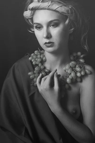 Portrait girl with scarf on head and grapes and onу naked breast in black and white