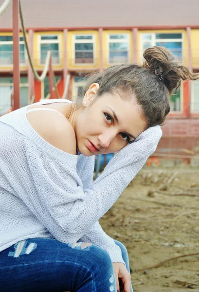 Portrait of casual dressed girl with hair bun in city background
