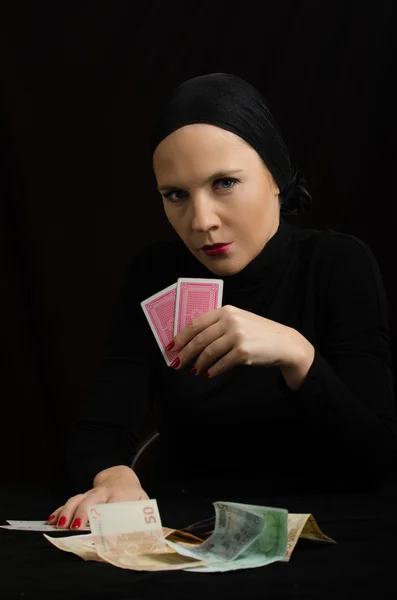 Woman with playing cards and money