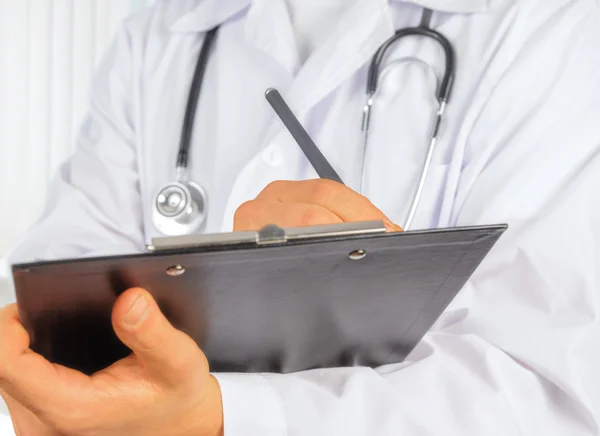 Unrecognizable physician with clipboard