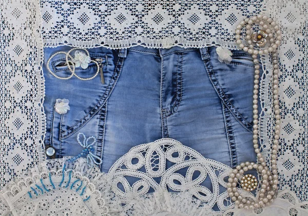 Denim background with lace and women\'s jewelry