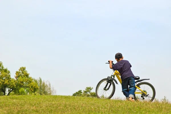 A boy riding a bike in the park