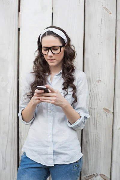 Trendy woman with stylish glasses sending text message