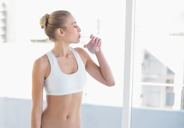 Peaceful young blonde model drinking water