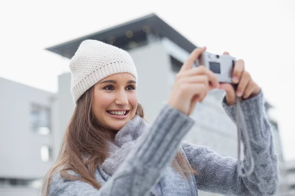 Smiling gorgeous woman with winter clothes on taking a self picture