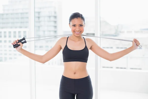 Pretty model in sportswear holding a skipping rope