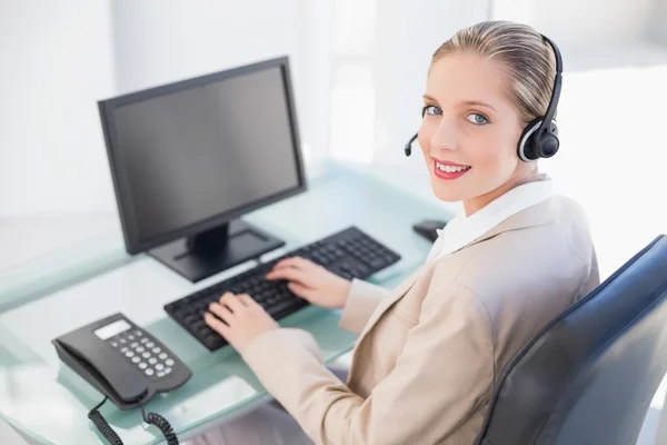 Smiling blonde call centre agent typing