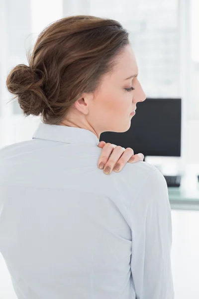 Businesswoman with neck pain in front of computer in office