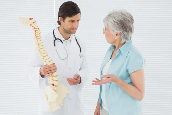 Male doctor explaining the spine to a senior patient