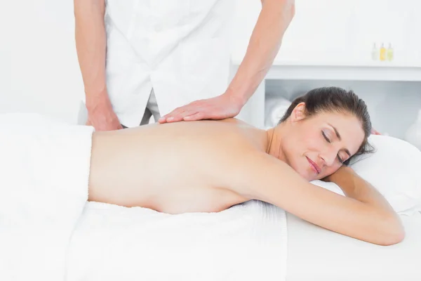 Male physiotherapist massaging woman\'s back