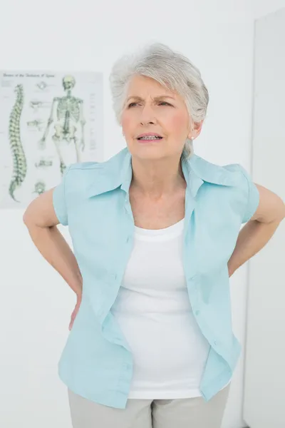 Senior woman with back pain in medical office