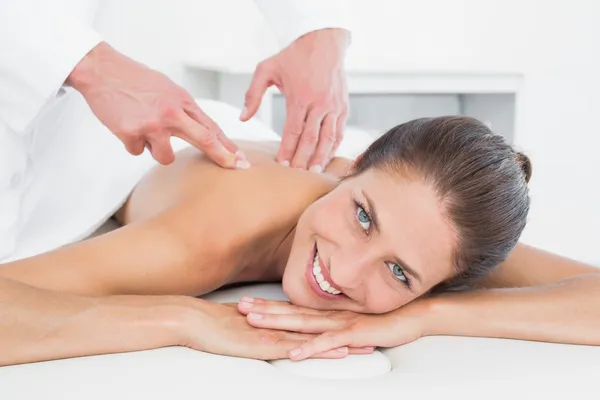 Male physiotherapist massaging woman\'s back