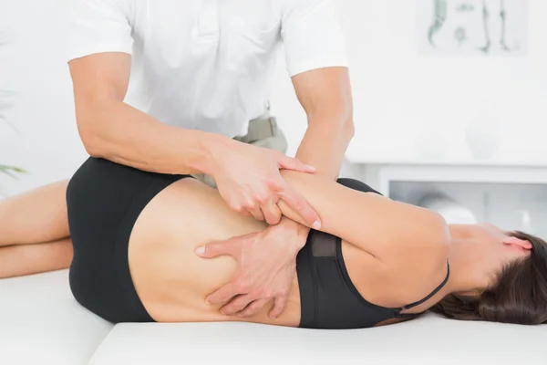 Physiotherapist massaging woman\'s back in medical office