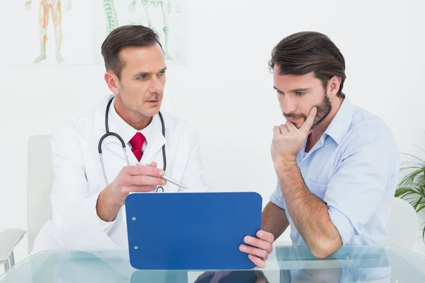 Doctor discussing reports with patient at medical office