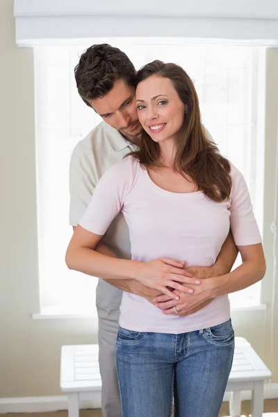 Loving young man embracing woman from behind