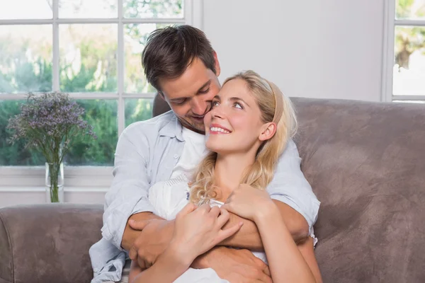 Relaxed loving man embracing woman in living room
