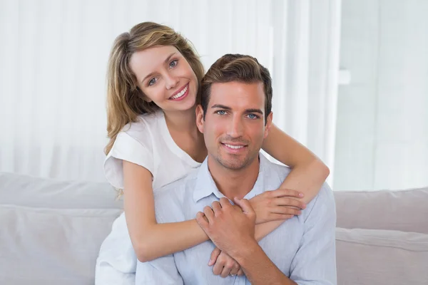 Loving young woman embracing man at home