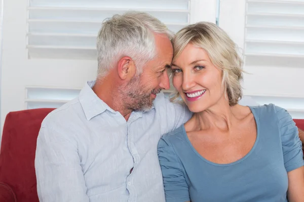 Smiling mature couple sitting on couch